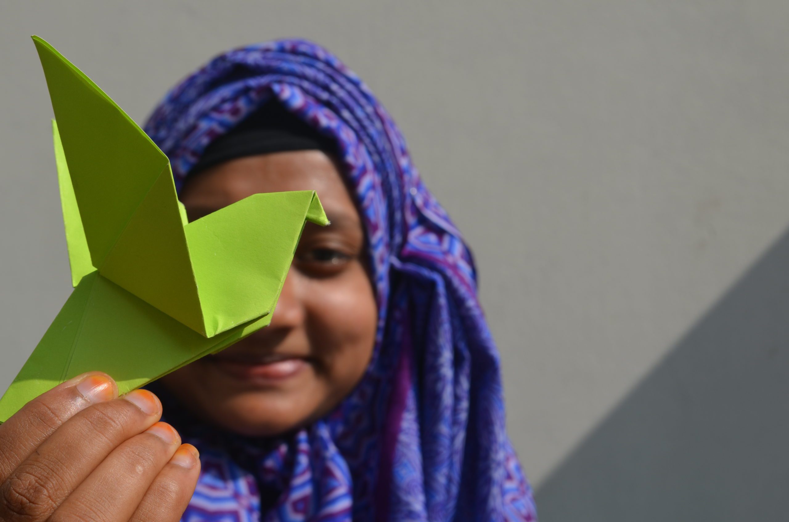 A girl holding a paper bird